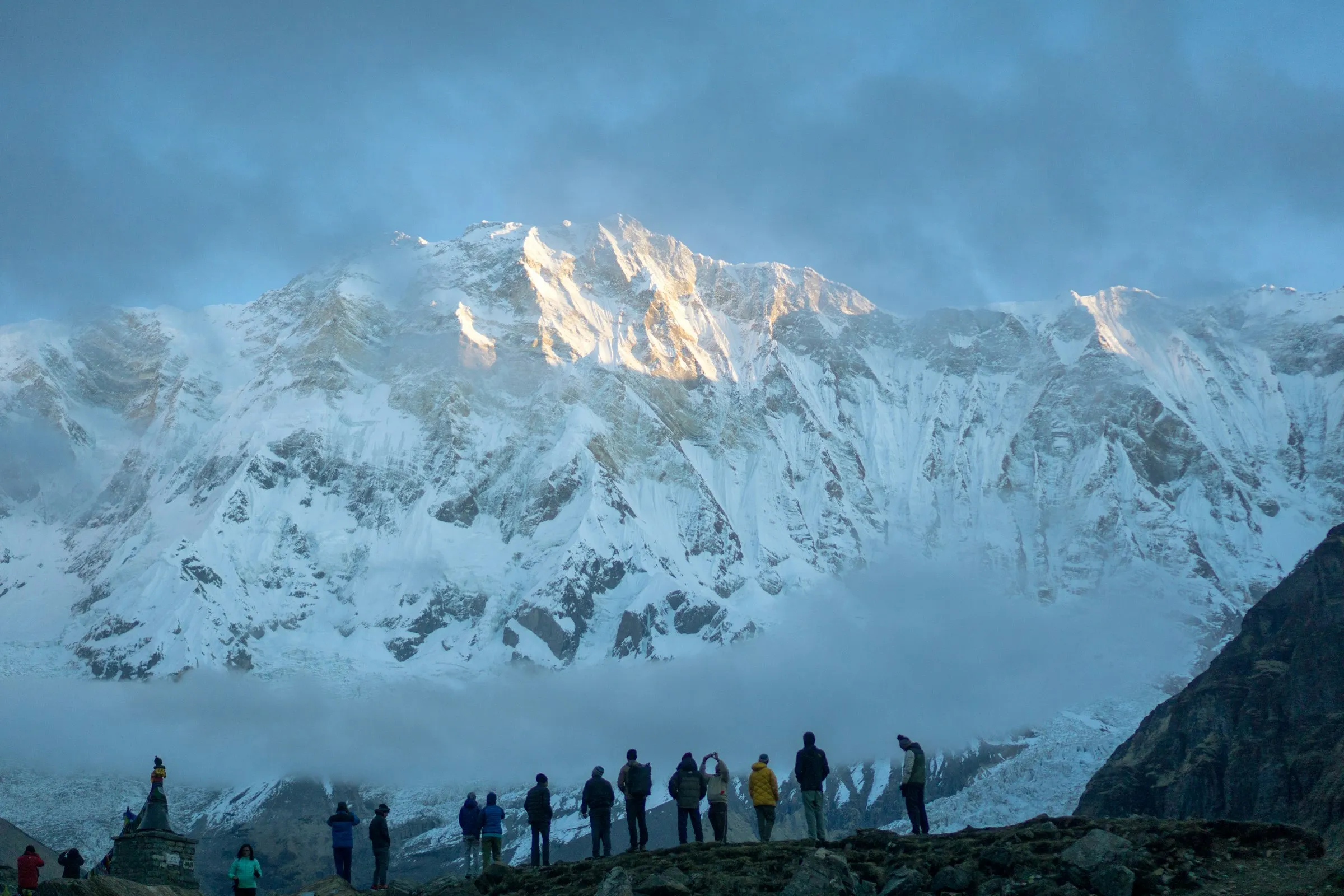 Trekkers at Annapurna Base Camp surrounded by snow peaks