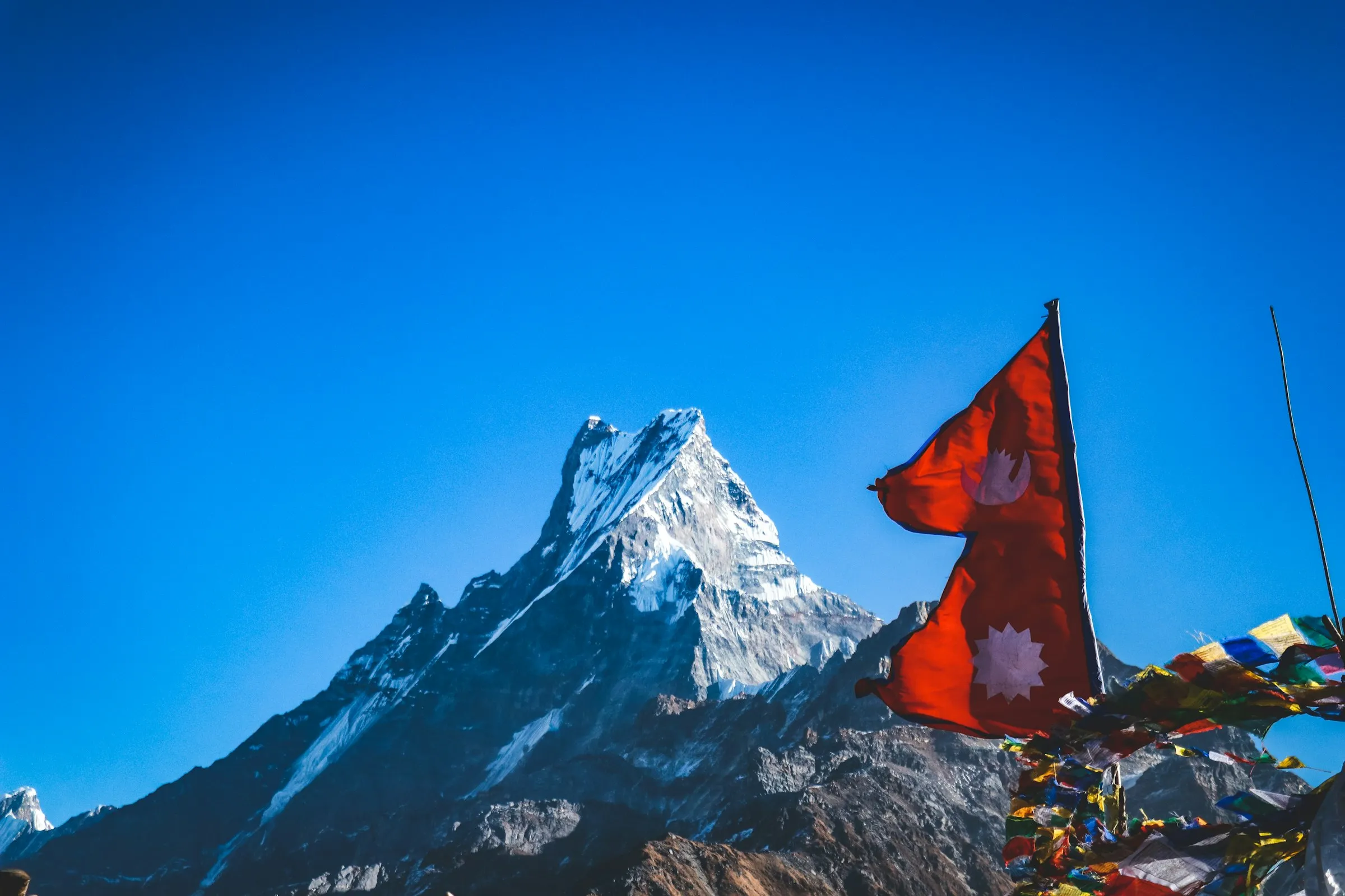 Nepali flag and prayer flags below Machapuchare on the Mardi Himal trek